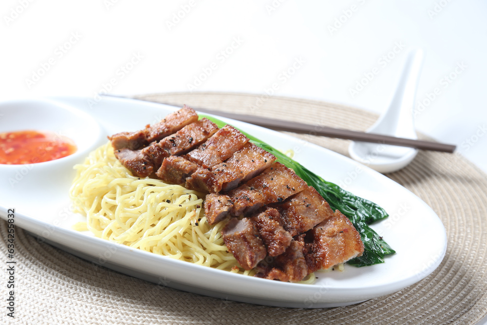 cook dry egg noodle mee with grilled chicken chop, pork cutlet and vegetable in soy chilli sauce in plate chopstick on brown cloth white table asian chef cuisine halal food menu for restaurant