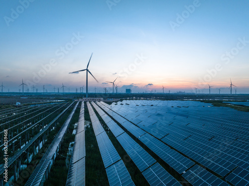Solar power plant and Windmills aerial view at sunset. Renewable energy. Green tech.