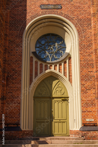 Green door and ornate round window of the Church of Loviisa in Finland photo