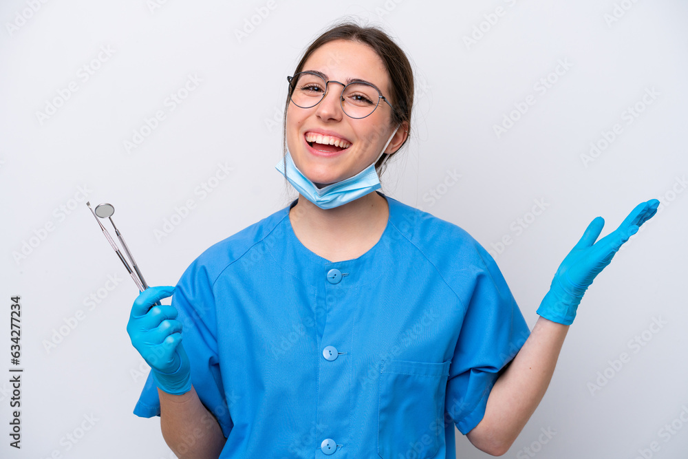 Dentist caucasian woman holding tools isolated on white background with shocked facial expression Dentist caucasian woman holding tools isolated on white background with shocked facial expression