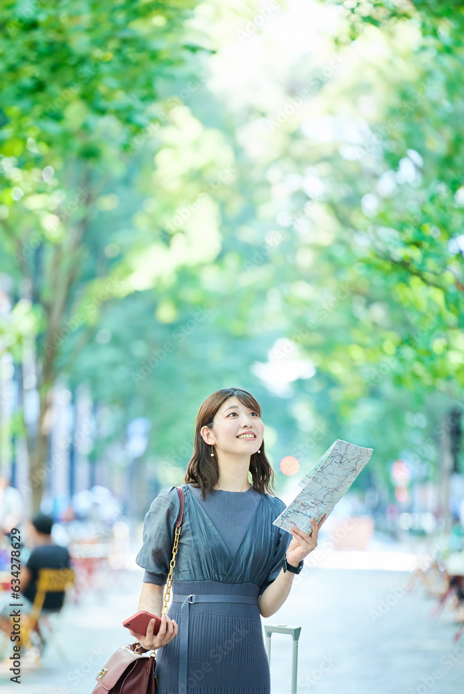 地図とスマホを手にする女性 地図とスマホを手にする女性