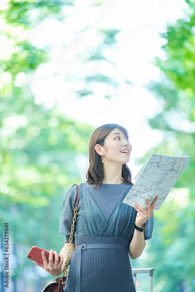 Naklejka premium 地図とスマホを手にする女性