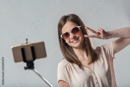 Foto Woman in sunglasses takes selfie; aspiring influencer