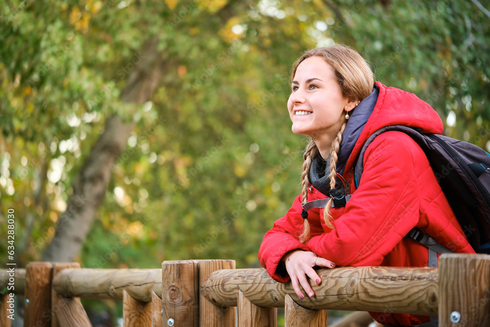 Smiling young female trekker contemplating views in the forest. Smiling young female trekker contemplating views in the forest.