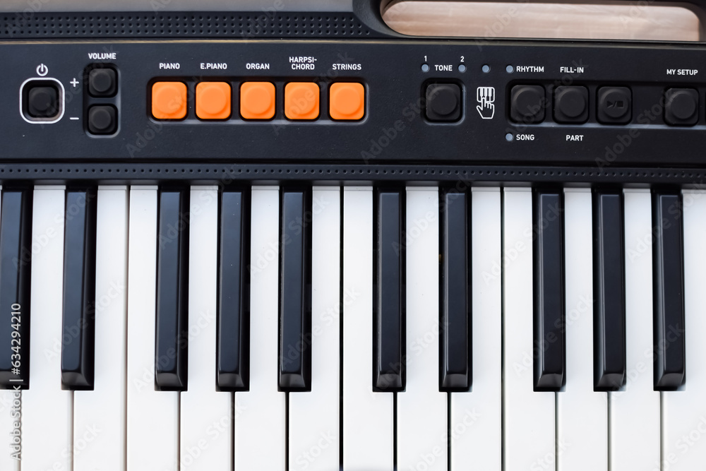 Close-up of piano keys. Piano black and white keys and Piano keyboard musical instrument placed at the home balcony during sunny day. Close-up of piano keys. Piano black and white keys and Piano keyboard musical instrument placed at the home balcony during sunny day.