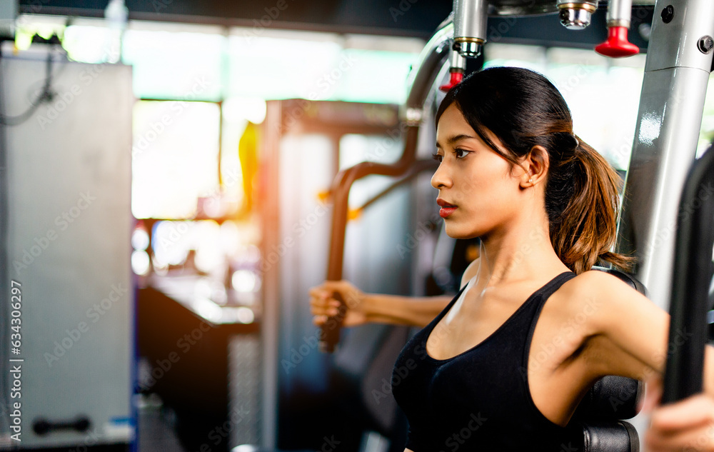 Exercise your arms with this arm exercise machine. healthy women exercise in fitness gym Exercise your arms with this arm exercise machine. healthy women exercise in fitness gym