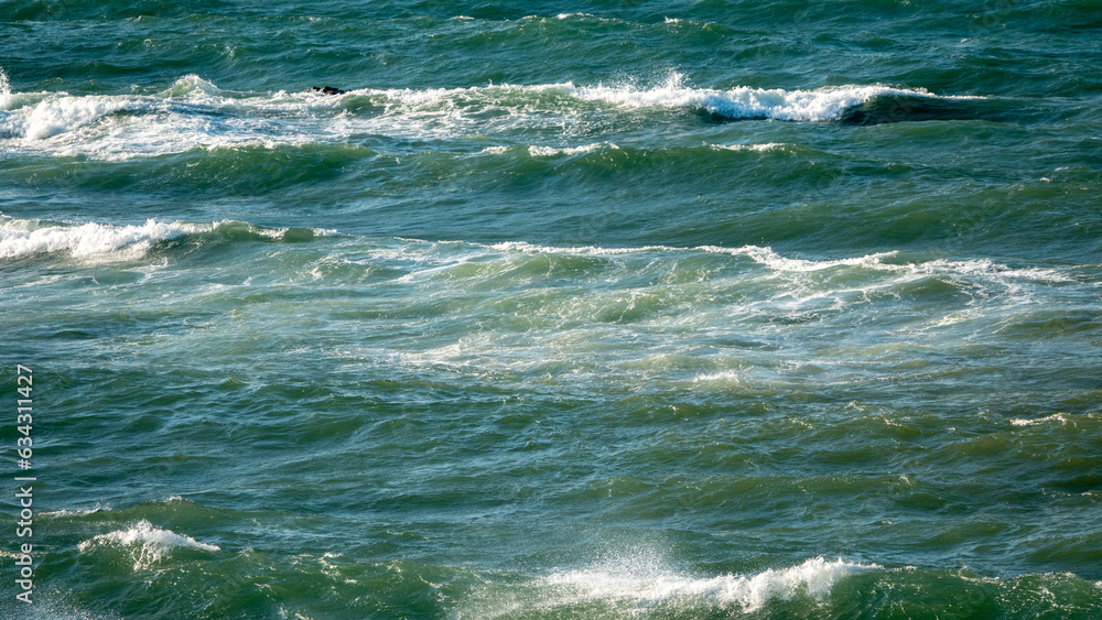 Waves splashing the rocks in the Aegean Sea on a windy day, sea foam and rocks in the sea  Gokceada, Imbros island. Aegean Turkey