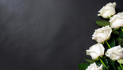 Fresh, white roses on black, dark background. Condolence card. Empty place for emotional, sentimental text, quote or sayings. Top view. Flat lay.