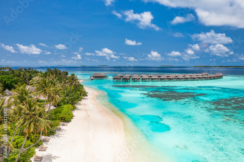 Stunning aerial landscape, luxury tropical resort with water villas. Beautiful island beach, palm trees, sunny sky. Amazing bird eyes view in Maldives, paradise coast. Exotic tourism, relax nature sea © icemanphotos