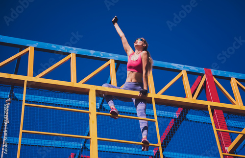 Athletic young woman working out and climbing at the training camp.