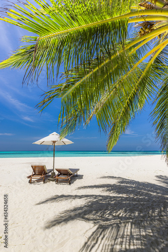 Amazing beach. Romantic chairs umbrella on sandy beach palm leaves  sun sea sky. Summer holiday  couples vacation. Love happy tropical landscape. Tranquil island coast relax beautiful landscape design