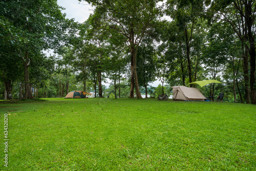 nature landscape camping or glamping cabin tent on green grass or lawn campground and tree for camper family holiday vacation on rainy season and cloudy at pom pee campsite in khao laem national park photo
