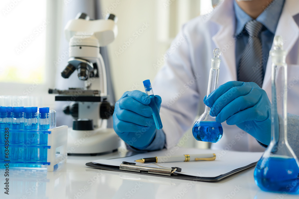 Researchers work in blue liquid test tube analyzes in chemical science laboratories or microscopic medical biology experimental technologies. Researchers work in blue liquid test tube analyzes in chemical science laboratories or microscopic medical biology experimental technologies.