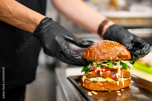 Print op canvas chef hand cooking cheese burger with vegetables and meat on restaurant kitchen