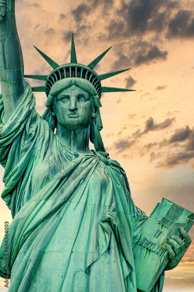 Fototapeta premium New York, New York, United States. August 07, 2023. Dramatic and detailed image of the Statue of Liberty with strong shades of green, sky with many clouds and very high resolution.