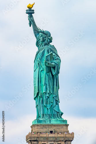 New York  New York  United States. August 07  2023. Dramatic and detailed image of the Statue of Liberty with strong shades of green  sky with many clouds and very high resolution.