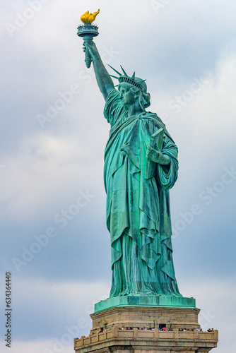 New York  New York  United States. August 07  2023. Dramatic and detailed image of the Statue of Liberty with strong shades of green  sky with many clouds and very high resolution.
