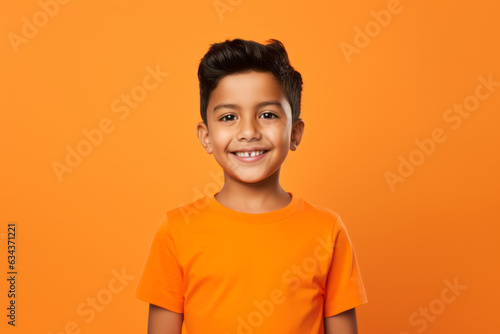 Smiling Mexican Boy on Vibrant Orange Studio Background