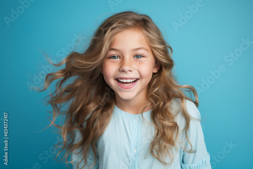 Joyful Caucasian Girl with Radiant Smile on Vibrant Blue Studio Background