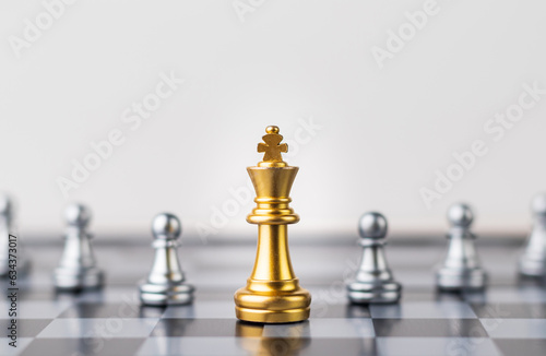 Leader  business strategy and planning concept  Gold Chess king figure on Chessboard and surrounded by a number of fallen silver chess pieces against opponent or enemy. Conflict  tactic  politic.