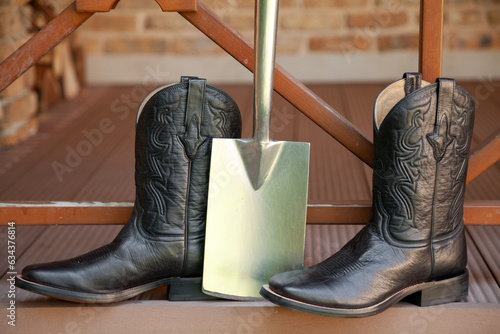 Картината върху платно Men cowboy boots stand on veranda of ranch..