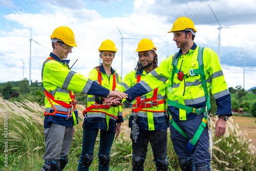 Wind turbine Engineer team working in wind turbine farm, join hands in unity