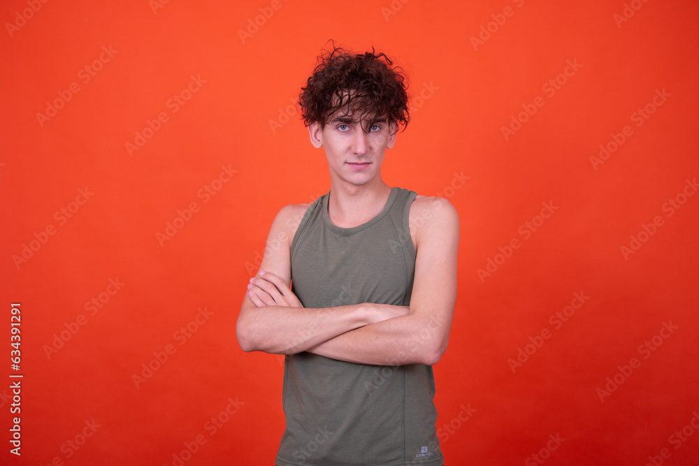 Funny curly guy posing on an orange background with different emotions. Funny curly guy posing on an orange background with different emotions.