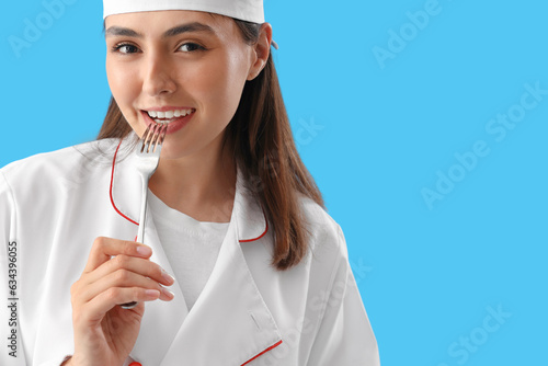 Female chef with fork on bl...
