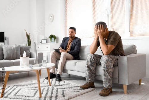 Male psychologist working with stressed mature soldier in office