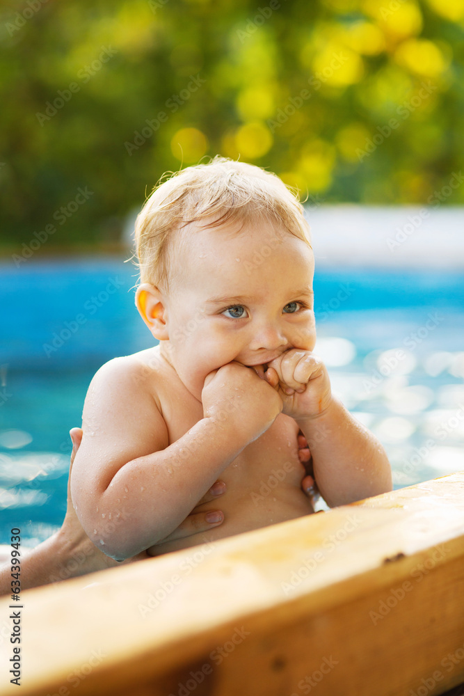 Portrait of small red-haired boy bathes in pool with hand support, baby swimming in water, summer leisure Portrait of small red-haired boy bathes in pool with hand support, baby swimming in water, summer leisure