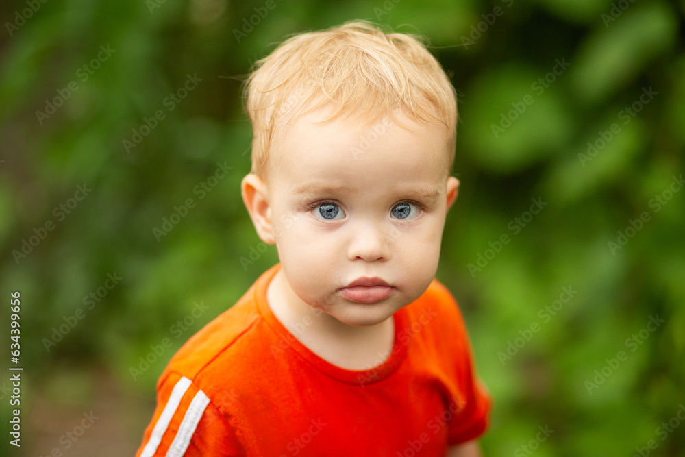 Summer portrait of small red-haired boy on nature. Concept of happy family and childhood Summer portrait of small red-haired boy on nature. Concept of happy family and childhood