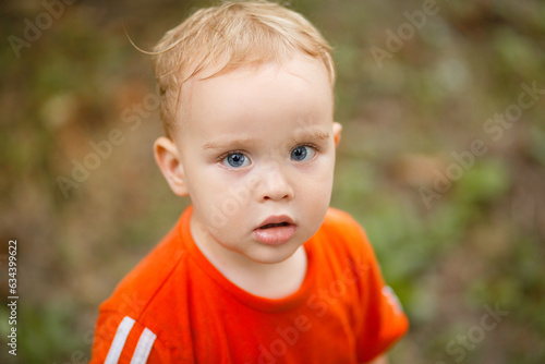 portrait of small blond boy on nature background, baby face
