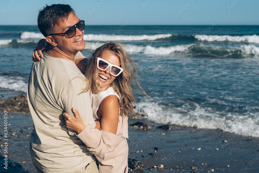 boyfriend and girlfriend husband and wife on vacation at sea have fun hugging and laughing on the beach near the sea