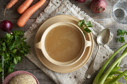 Chicken bone broth in a soup plate on a table