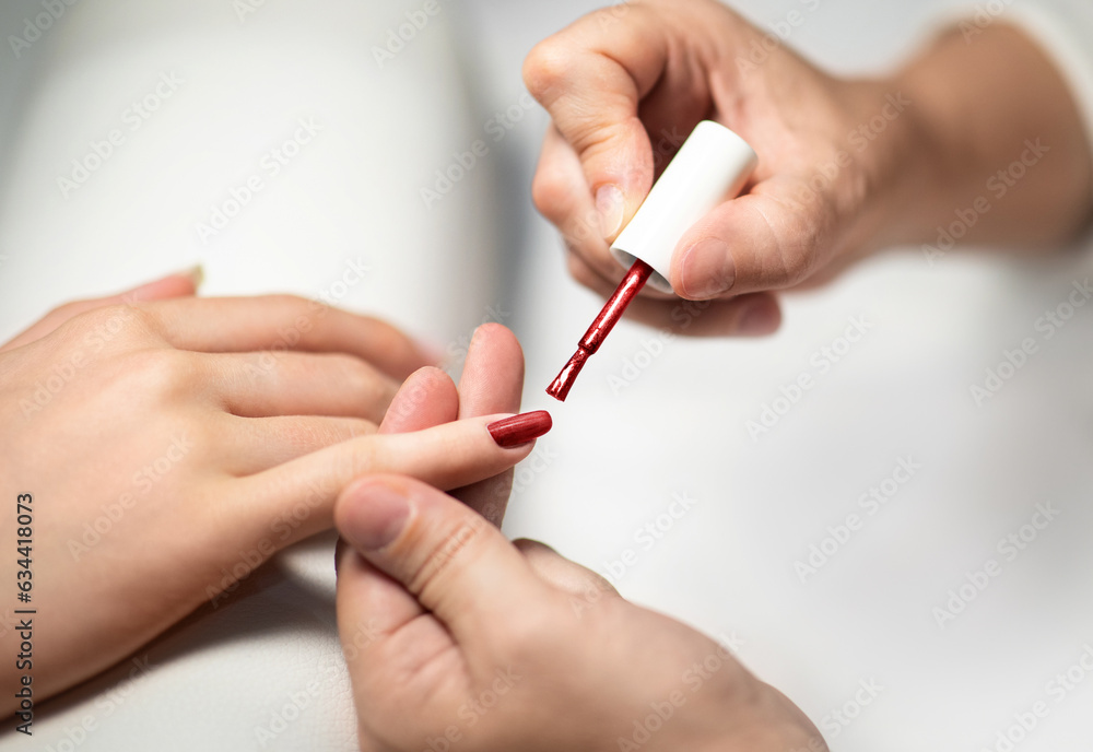 Female Hands While Manicurist Applying Polish On Fingernails Indoor, Closeup Female Hands While Manicurist Applying Polish On Fingernails Indoor, Closeup