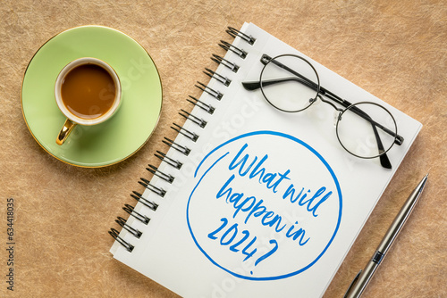 What will happen in 2024 ? Handwriting in a spiral notebook with a cup of coffee. Personal, business and financial trends and expectations in New Year.