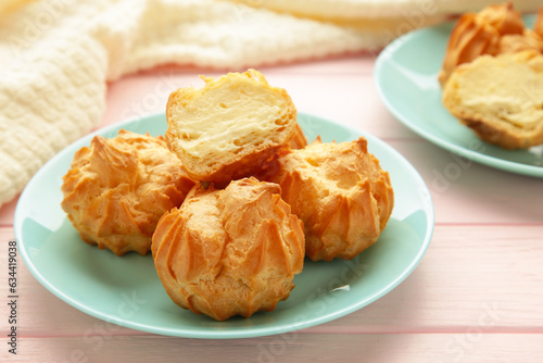 Canvas-taulu Homemade profiteroles with cream on plate on pink background