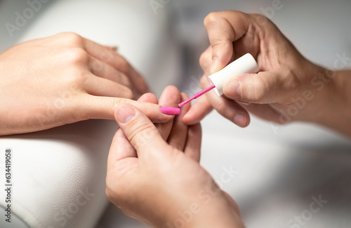 Manicurist Applying Gel Polish On Client's Fingernails, Closeup Of Hands