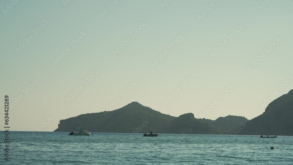 Video of boats gently swaying in the sunny sea, moored not far from the beach, on a hot day Video of boats gently swaying in the sunny sea, moored not far from the beach, on a hot day