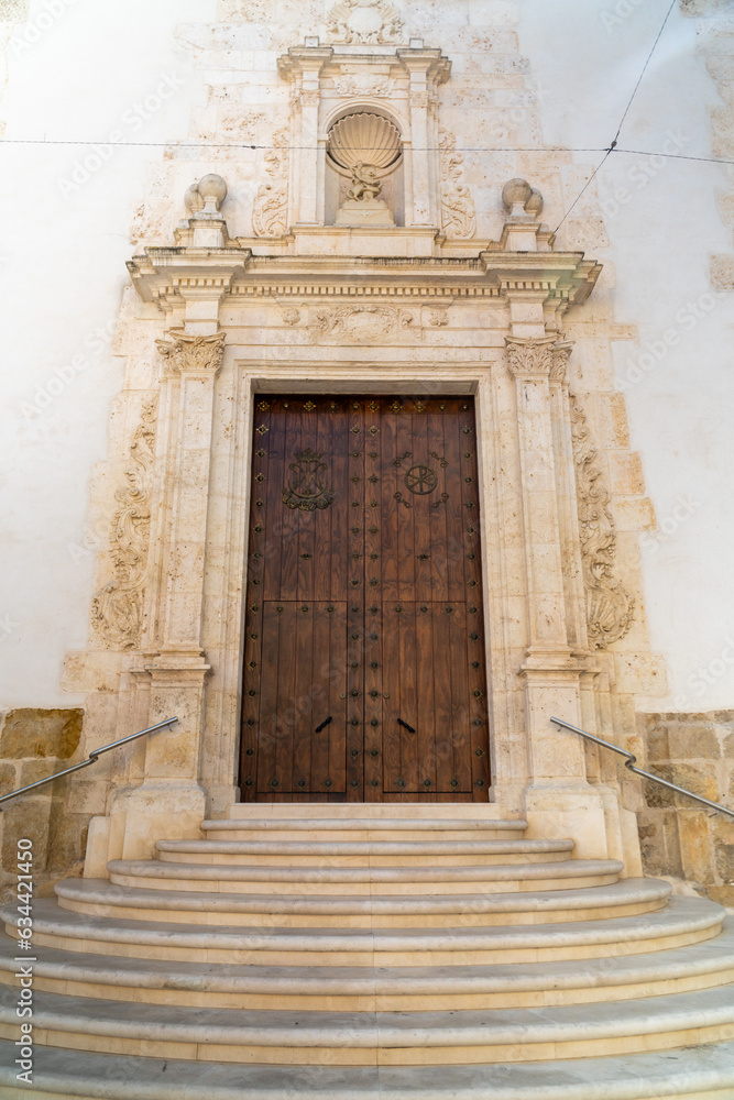  Stairs and wooden door at the entrance of the church of Banyeres, Alicante (Spain).