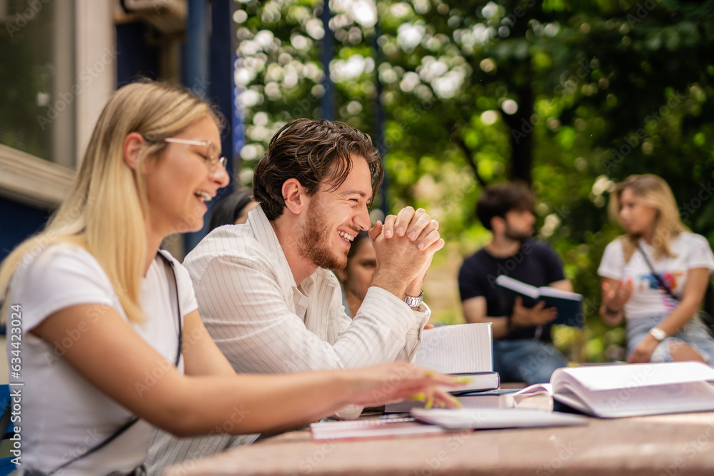 Handsome male student laughing during college break with his colleagues Handsome male student laughing during college break with his colleagues