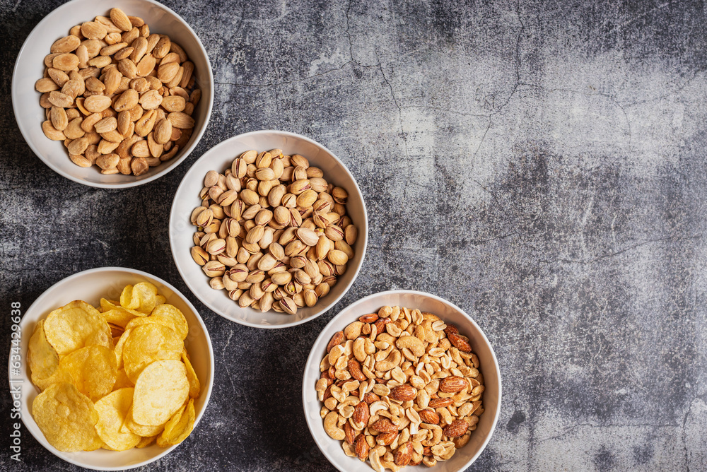 Bowls with chips and nuts, almonds, pistachios and a mix of peanuts