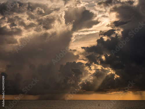 Fotografie Precipitation shafts and penetrative sunbeams intensify the visual drama of offs