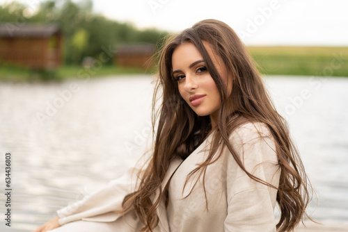 beautiful girl with long hair posing outdoors on the lake shore.