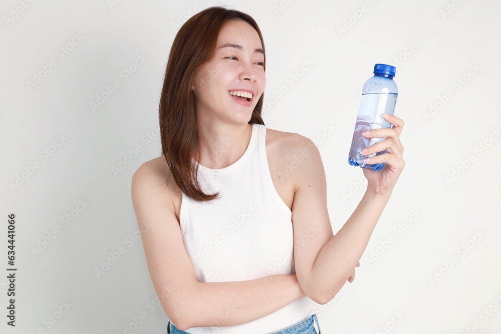woman holding bottle of water standing over isolated background. woman holding bottle of water standing over isolated background.