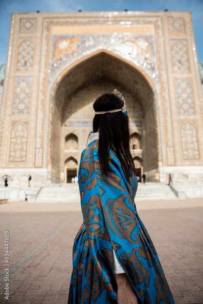 Uzbek woman in traditional dress in Registan square Samarkand, Uzbekistan