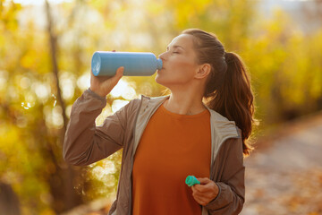 trendy female in fitness clothes in park