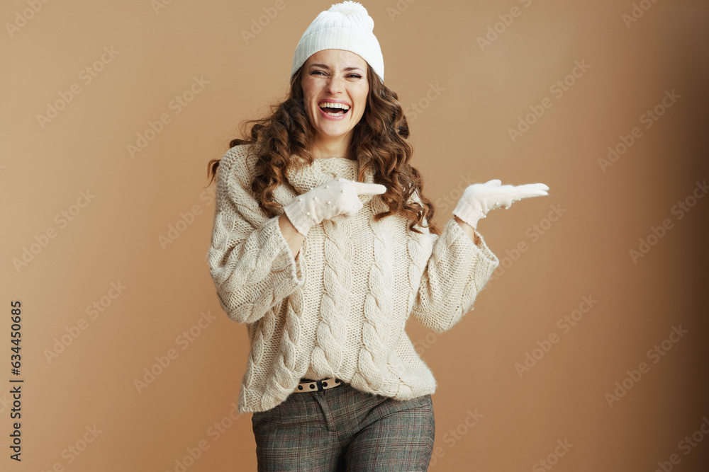 woman presenting something on empty palm isolated on beige woman presenting something on empty palm isolated on beige