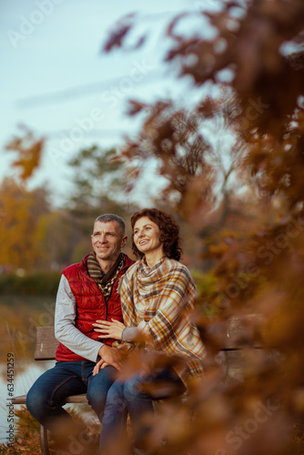happy romantic couple in park while sitting on bench