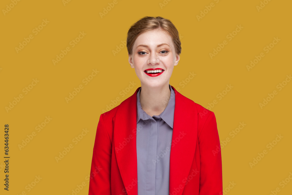 Φωτογραφία Portrait of happy satisfied woman with red lips standing looking at camera with toothy smile, expressing happiness, wearing red jacket
